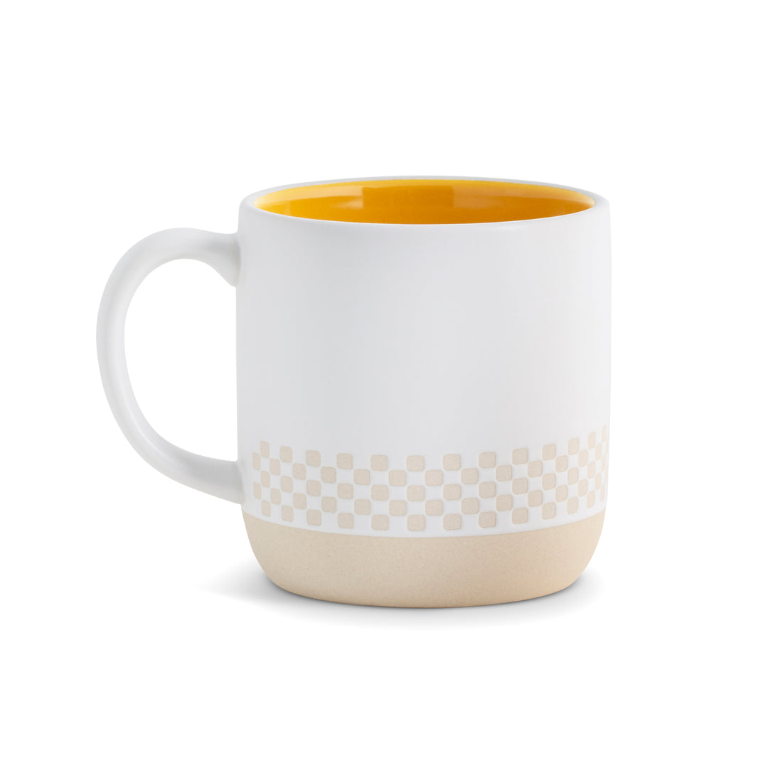White mug with yellow interior, beige patterned band, and beige base on a white background