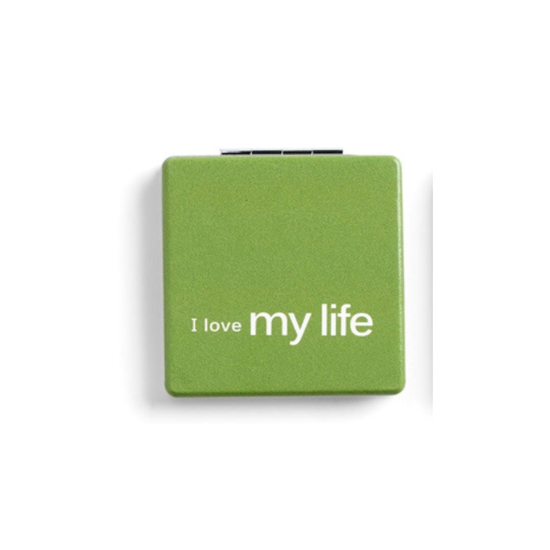 Green pocket mirror with 'I love my life' text on a white background